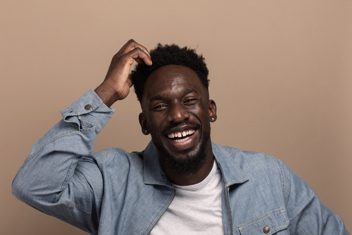 Studio portrait of a young man laughing.